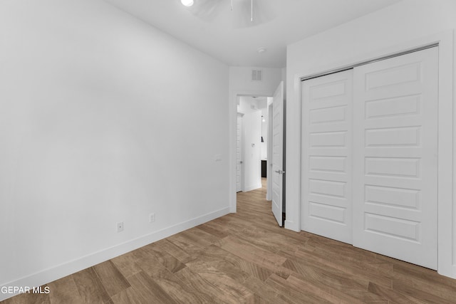 unfurnished bedroom featuring wood-type flooring and a closet