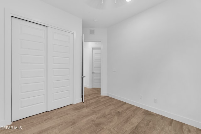 unfurnished bedroom featuring a closet and light hardwood / wood-style floors