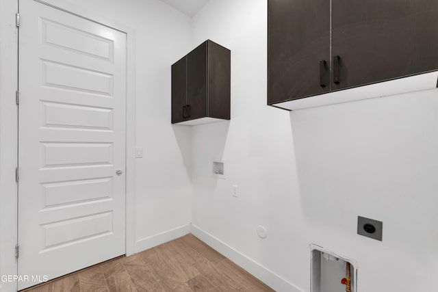 washroom with light wood-type flooring, cabinets, hookup for an electric dryer, hookup for a washing machine, and gas dryer hookup