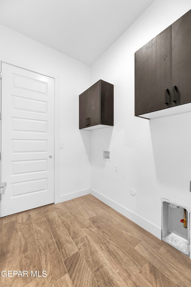 clothes washing area with light wood-type flooring, cabinets, and washer hookup