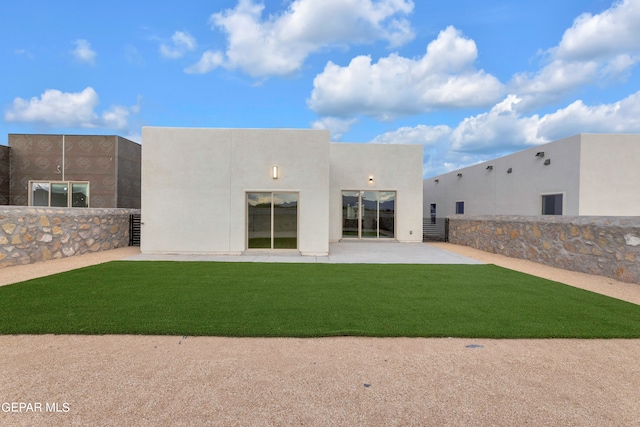 back of property featuring a lawn and a patio area