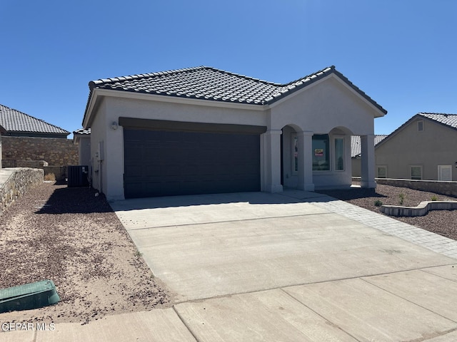 view of front of property featuring central AC and a garage