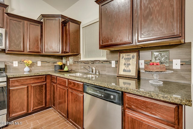 kitchen featuring backsplash, stone countertops, range, dishwasher, and sink