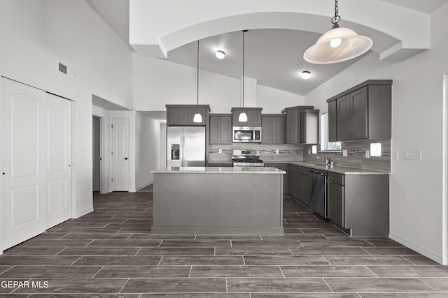 13158 Ludlow Ln, El Paso, TX 79928 - kitchen featuring stainless steel appliances, wood tiled floors, a center island, light stone countertops, and high vaulted ceiling