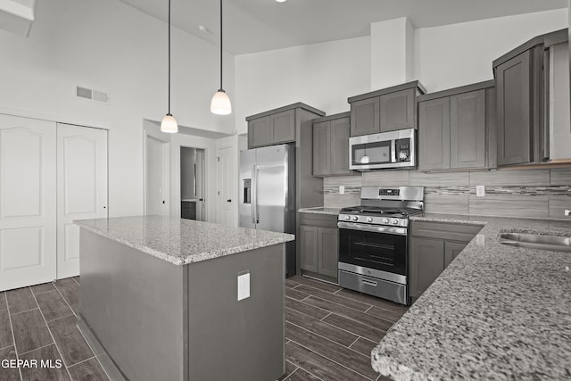 13158 Ludlow Ln, El Paso, TX 79928 - kitchen with appliances with stainless steel finishes, high vaulted ceiling, wood finish floors, a center island, and gray cabinets