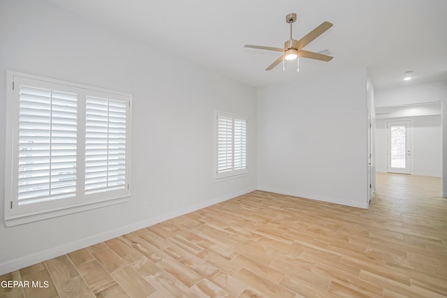 unfurnished room featuring light hardwood / wood-style floors, ceiling fan, and a wealth of natural light