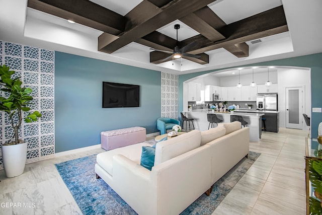 living room with beam ceiling, ceiling fan, coffered ceiling, and sink