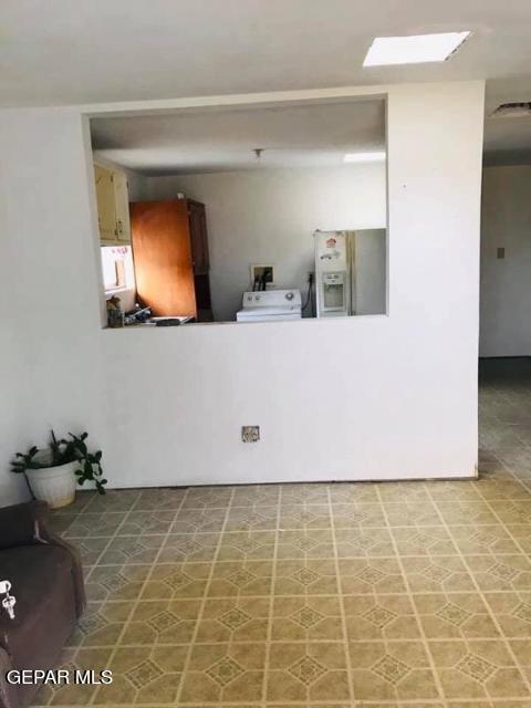 living room with tile patterned flooring, washer / clothes dryer, and a skylight