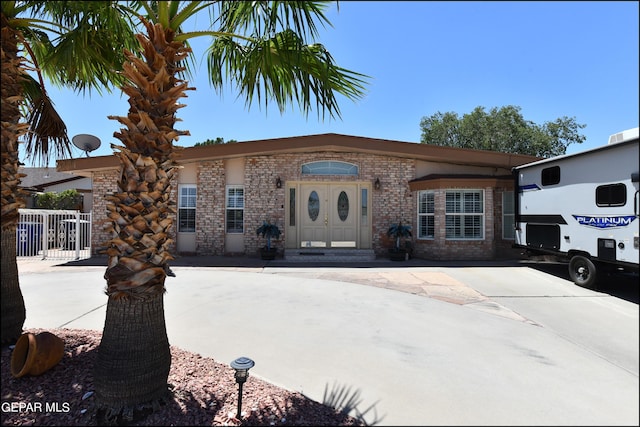 view of front of property featuring brick siding and fence