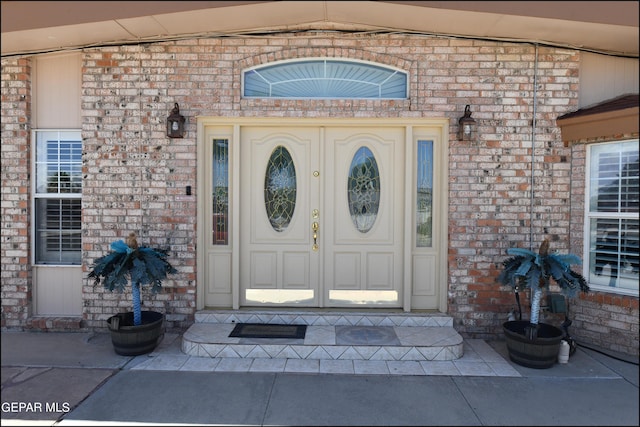 doorway to property with brick siding