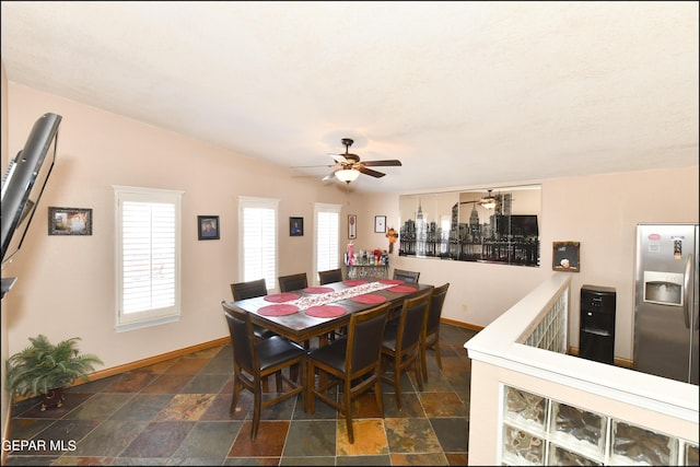 dining space featuring stone finish floor, baseboards, and a ceiling fan