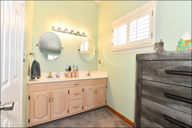 bathroom featuring double vanity, baseboards, and a sink