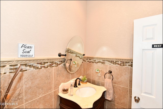 bathroom with wainscoting, tile walls, and vanity