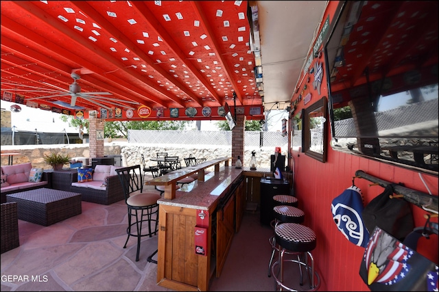 view of patio featuring outdoor dry bar, an outdoor living space, fence, and a ceiling fan