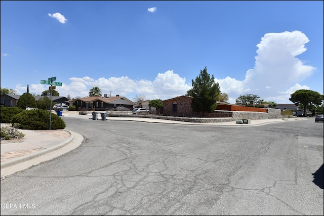 view of street with a residential view, curbs, and sidewalks