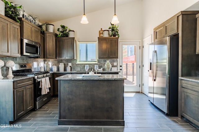 kitchen with light stone counters, backsplash, a healthy amount of sunlight, and stainless steel appliances