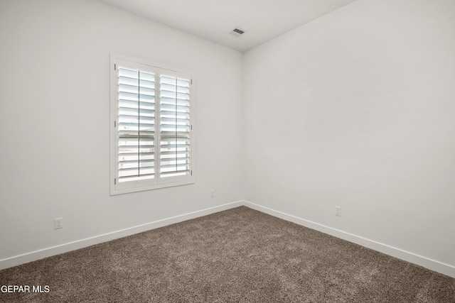 carpeted empty room featuring baseboards