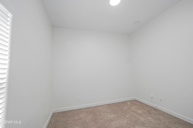 spare room featuring light colored carpet