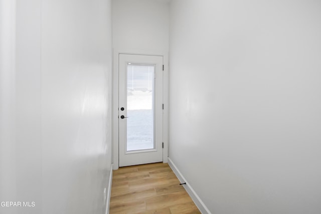 doorway with light hardwood / wood-style floors and a wealth of natural light