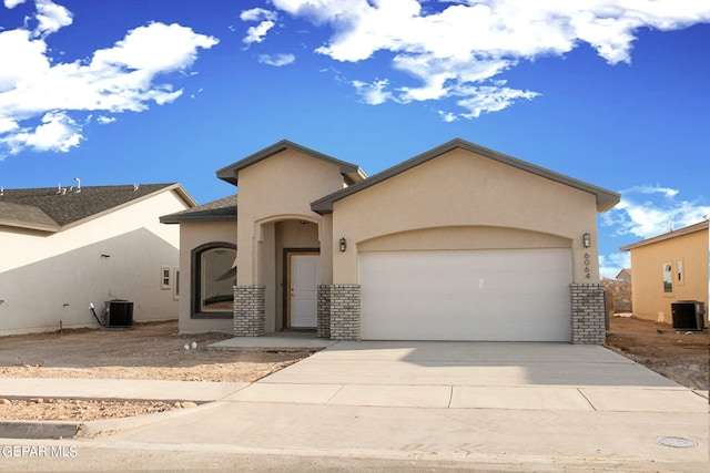 view of front of home with central AC unit and a garage