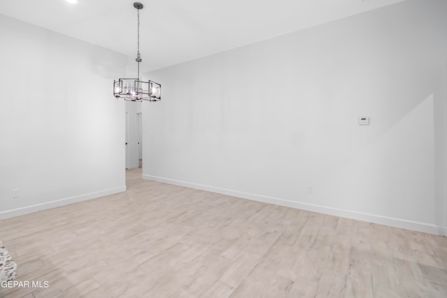 unfurnished room with light hardwood / wood-style floors and a chandelier