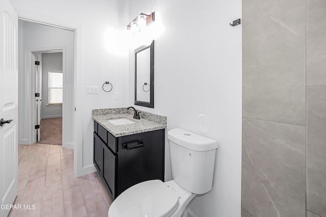 bathroom featuring vanity, hardwood / wood-style floors, and toilet