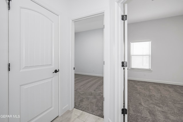 hallway featuring light colored carpet