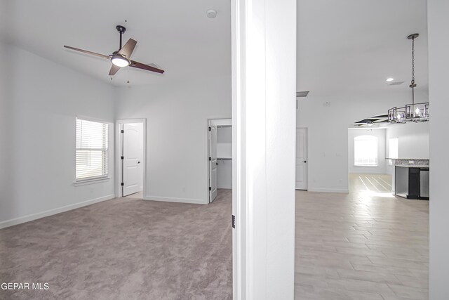 interior space with ceiling fan and light carpet