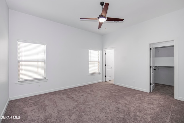 unfurnished bedroom featuring carpet flooring, ceiling fan, a walk in closet, and a closet