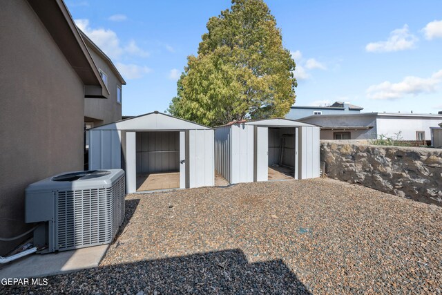 view of yard featuring central AC unit and a storage unit