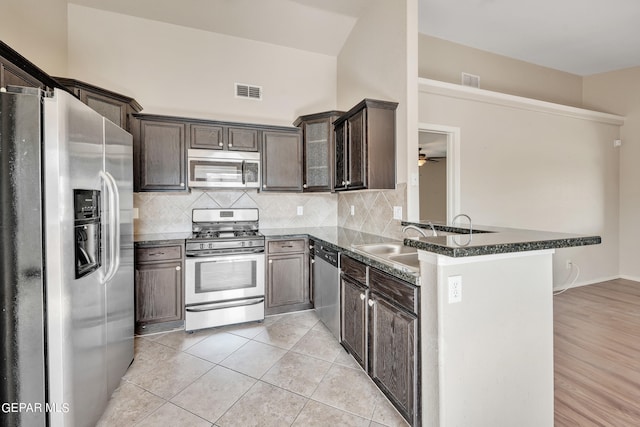 kitchen featuring stainless steel appliances, light hardwood / wood-style floors, tasteful backsplash, kitchen peninsula, and ceiling fan