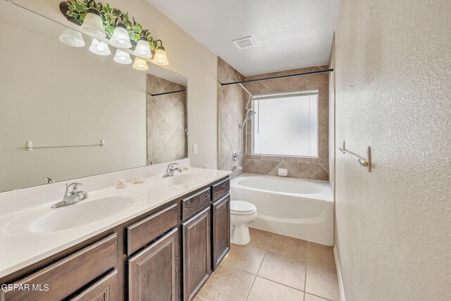 bathroom featuring tile patterned flooring, toilet, a textured ceiling, and dual vanity