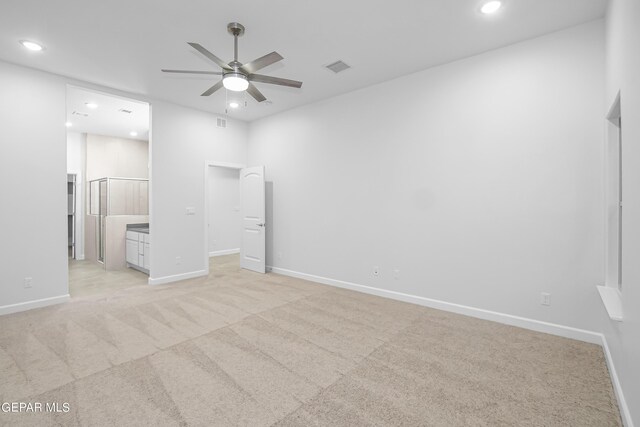 unfurnished bedroom with light carpet, ensuite bath, and ceiling fan