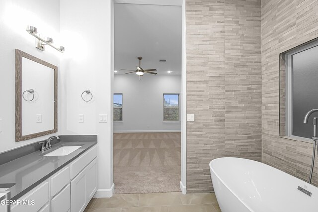 bathroom featuring ceiling fan, vanity, tile patterned flooring, and a bath