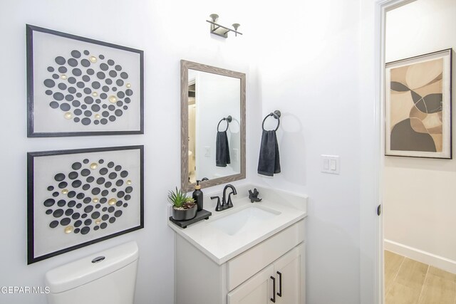 bathroom with hardwood / wood-style floors, vanity, and toilet