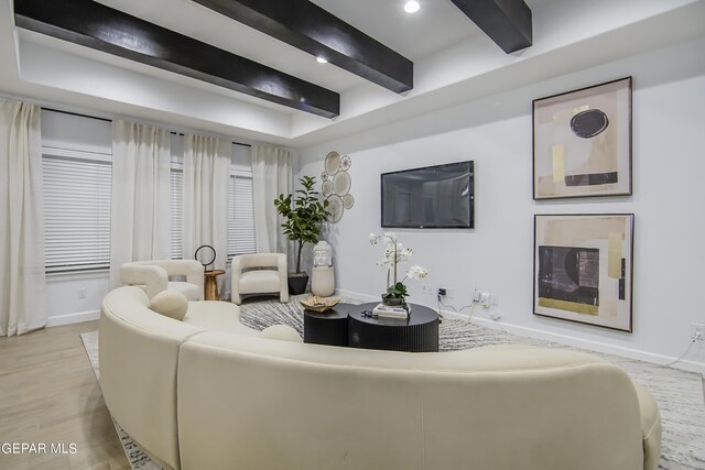 living room featuring beamed ceiling and light hardwood / wood-style flooring