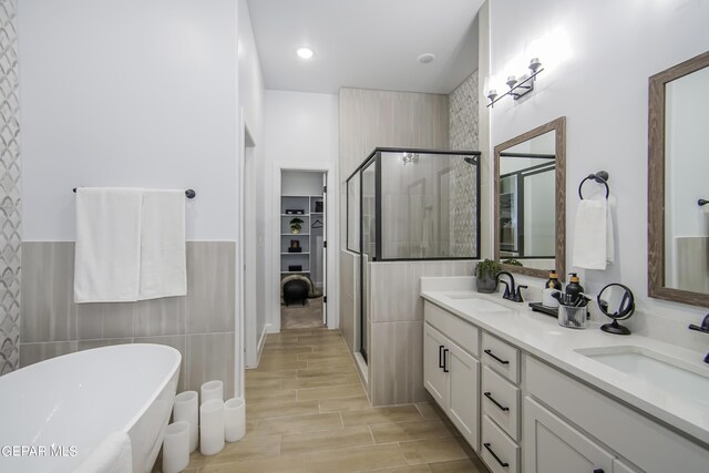 bathroom featuring tile walls, vanity, separate shower and tub, and hardwood / wood-style flooring