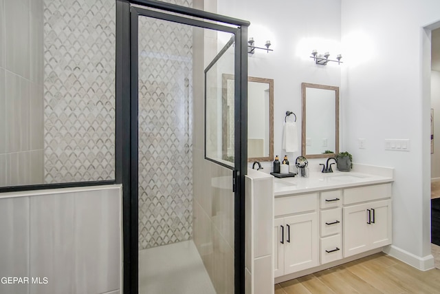 bathroom featuring walk in shower, vanity, and hardwood / wood-style floors