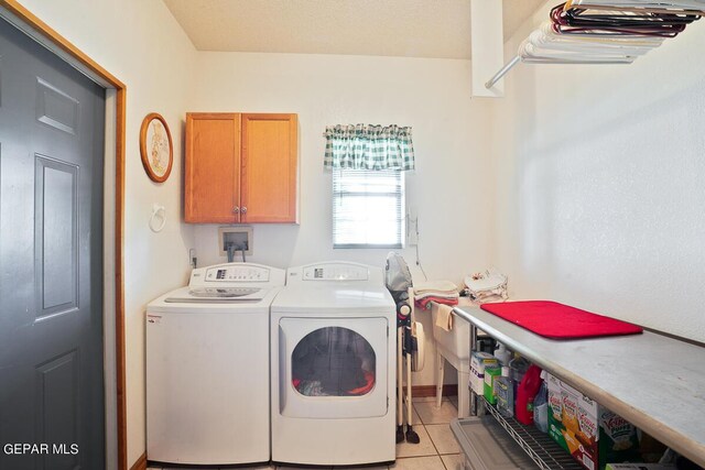 washroom featuring washer and clothes dryer, cabinets, and light tile patterned floors