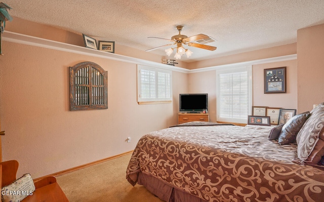 bedroom featuring carpet, ceiling fan, and a textured ceiling