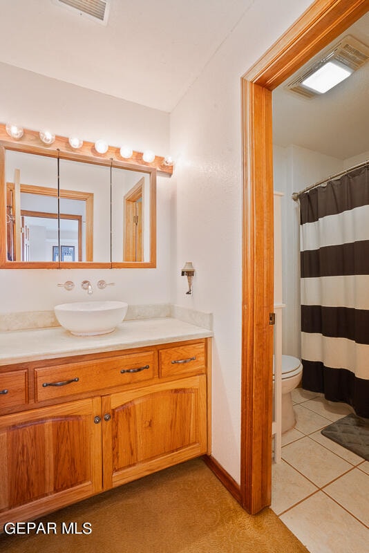 bathroom featuring tile patterned flooring, vanity, and toilet