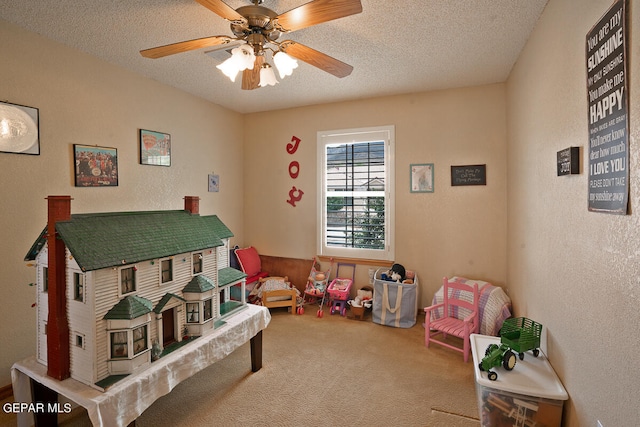 playroom with carpet floors, a textured ceiling, and ceiling fan