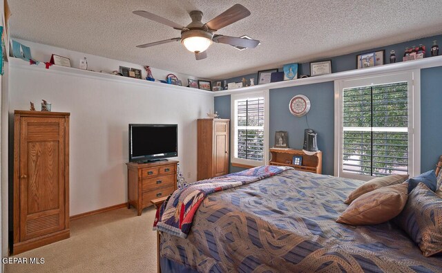 bedroom with light carpet, ceiling fan, and a textured ceiling