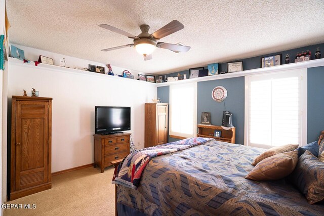 bedroom with light colored carpet, ceiling fan, a textured ceiling, and baseboards