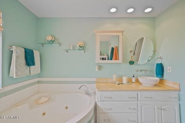 full bath with vanity and a whirlpool tub