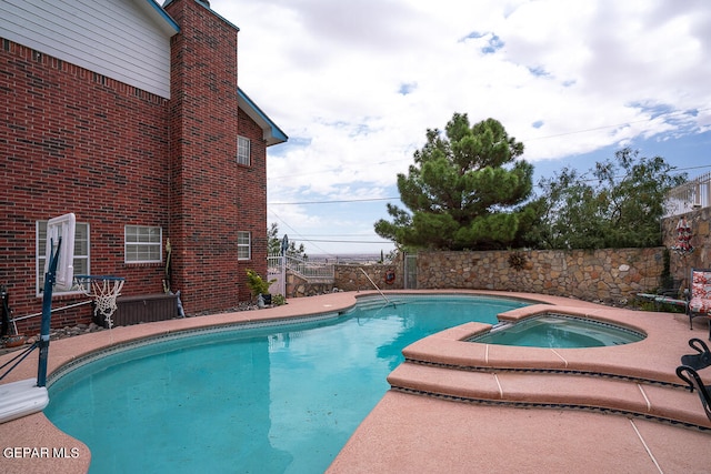 view of swimming pool with an in ground hot tub