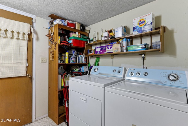 washroom with laundry area, a textured ceiling, and separate washer and dryer