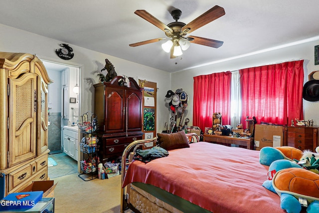 bedroom with ensuite bathroom, carpet flooring, and a ceiling fan