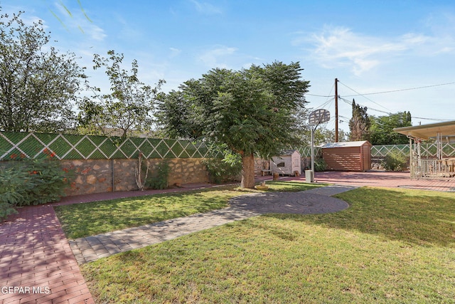 view of yard with a storage shed, an outdoor structure, and fence