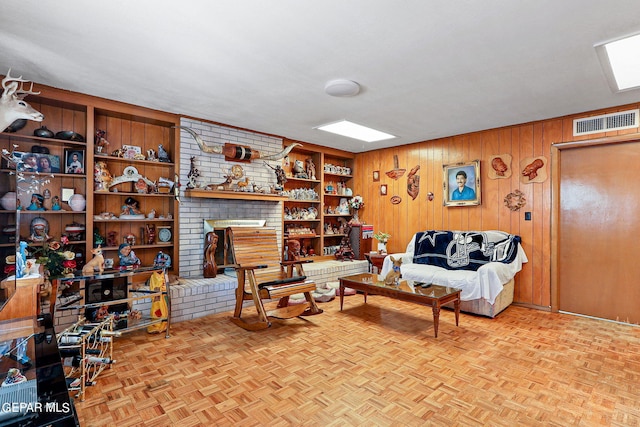 living area featuring a brick fireplace, visible vents, and wood walls